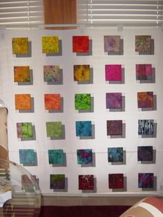 a wall hanging on the side of a window covered in lots of different colored squares