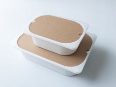 two white containers with brown paper on them