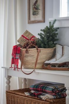 baskets and blankets are sitting on a shelf next to a christmas tree in a window sill