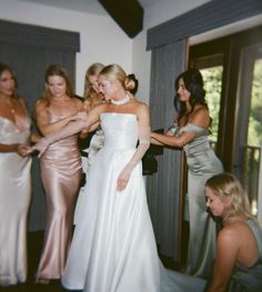 the bridesmaids are getting ready to get into their wedding dress for the ceremony