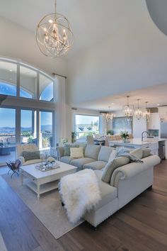 a living room filled with furniture next to a large window covered in lots of windows