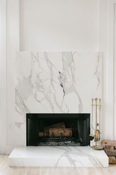 a fireplace with white marble and gold accents