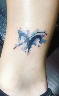 a woman's foot with a blue and black tattoo on the side of her leg