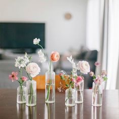 several vases with flowers in them sitting on a table