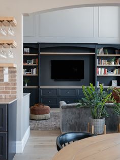 a living room filled with furniture and a flat screen tv mounted on the wall above a fireplace