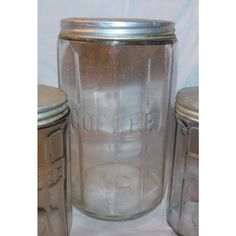 three glass jars with lids are sitting on a table