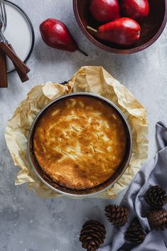 a pie sitting on top of a pan next to some apples