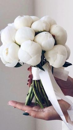 a person holding a bouquet of white flowers