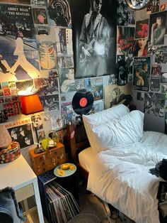 a bedroom with lots of posters on the wall and a bed in front of it