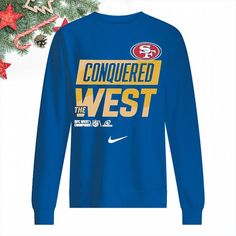 a blue sweatshirt with the words conquer west on it and a christmas tree in the background