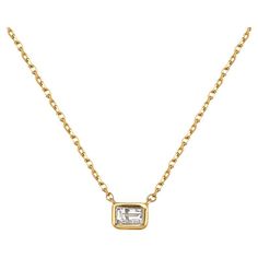 The Emerald Cut Diamond Solitaire Necklace is a classic and elegant piece of jewelry that is perfect for adding a touch of luxury and sophistication to any outfit. Featuring a beautiful emerald-cut diamond weighing 0.20 carats, the diamond is meticulously bezel-set in a high-quality 14K gold pendant. The emerald cut of the diamond creates a mesmerizing effect, catching the light from every angle and showcasing its natural beauty and brilliance. The pendant and chain are made of 14K gold, which p