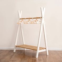 a wooden bench sitting on top of a hard wood floor next to a white wall