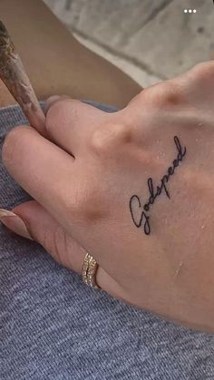 a woman's hand with a small tattoo on her left wrist and the word coffee written in cursive writing