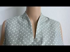 a mannequin wearing a gray and white polka dot top with collared neckline