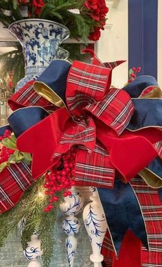 a red, white and blue christmas bow on top of a mantle