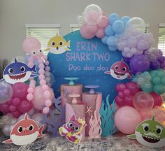 there are balloons and decorations on the table for a baby shark themed birthday party at home