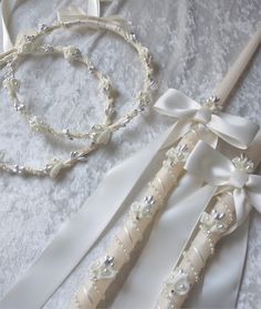 two wedding garters and a bracelet on a bed