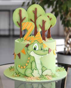 a birthday cake decorated with trees and an alligator