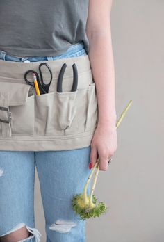 a person holding scissors and some vegetables in their pockets