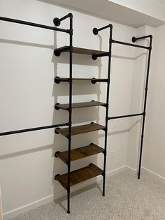 an empty room with several shelves and metal pipes on the wall next to each other