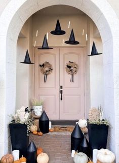 the front door is decorated with black cones and pumpkins