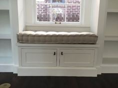 a window seat with built in bookshelves next to a bookcase and shelves