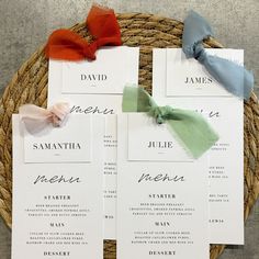 the wedding stationery is laid out on a wicker basket with ribbon and bows