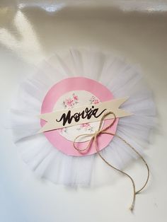 a pink and white flower with a name tag on it