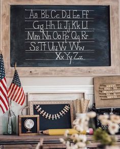 an american flag is on the table next to a blackboard with letters and numbers