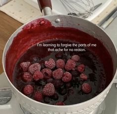 a pot filled with raspberries sitting on top of a stove