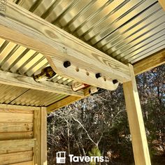 a wooden porch with metal roofing and wood posts