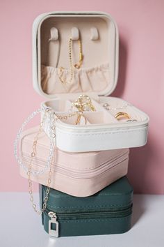 three suitcases stacked on top of each other with jewelry in them