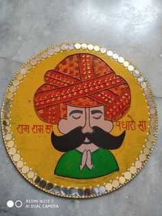 a yellow plate with a painting of a man wearing a turban on it