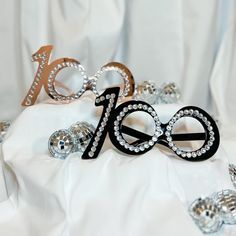 an image of the number twenty one hundred with beads and jewels on white cloth background