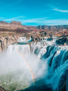 a rainbow in the sky over a waterfall