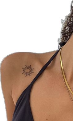 a woman with a sun tattoo on her left shoulder and neck, wearing a black tank top