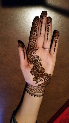 a woman's hand with henna tattoos on it