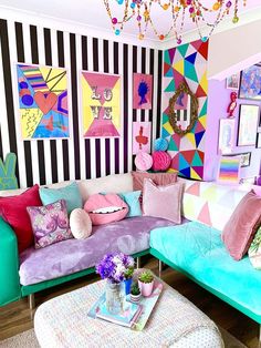 a living room filled with lots of colorful furniture and art on the wall behind it