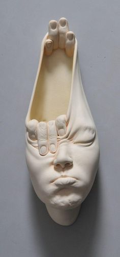 a ceramic sculpture of a face with teeth on it's head and mouth open