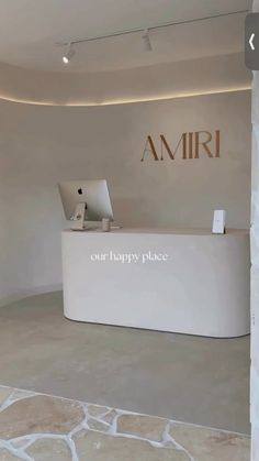 the front desk of an amri store is white and has a sign that says, our happy place