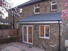 a brick house with a small patio and sliding glass doors on the front door area