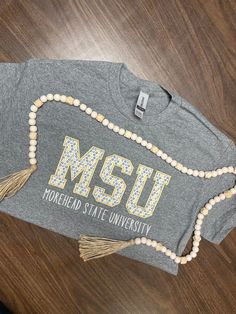 Our appliqué fabric will get you in the spirit of your next MSU Event!  our tees are Unsexed sized. Ready to Ship Time is 2 to 3 Weeks on all of my Listings. If ordered on 9/1/22, it will ship between 9/15 and 9/22/2022. This is an estimate of time and could vary a little. Please contact me if you need your order in a different time frame. We strive to make every customer happy, so please contact us if you have any concerns over sizing, colors or anything else before placing an order. Before lea Collegiate Cotton T-shirt With Embroidered Graphics, Cotton Tops With Embroidered Graphics For Fan Gear, Cotton Tops With Embroidered Graphics For Fans, Cotton Tops With Embroidered Graphics For Sports Events, Cotton Tops With Embroidered Graphics For Team Spirit, Fan Apparel Cotton T-shirt With Embroidered Graphics, Cotton College T-shirt With Embroidered Graphics, Cotton Tops With Embroidered Graphics For School Spirit, Collegiate Embroidered Cotton T-shirt