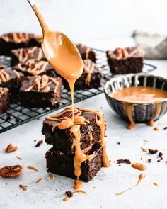 a spoon drizzling caramel sauce onto some brownies