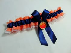 an orange and blue garter with a button on the side sitting on a white surface