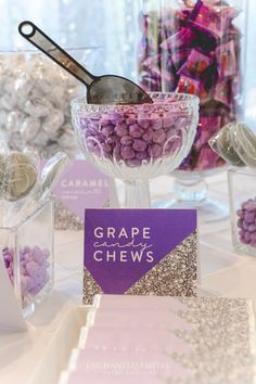 a table topped with candy and candies on top of glass bowls filled with candy