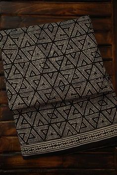 two black and white patterned towels sitting on top of a wooden table