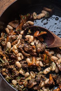 beans and meat are being cooked in a skillet