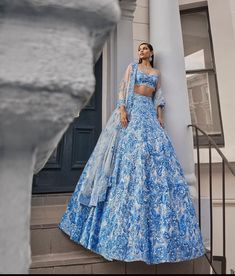 a woman in a blue and white dress standing on steps