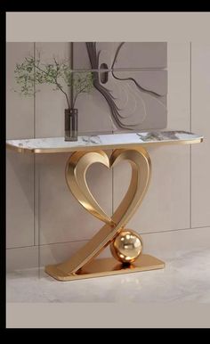 a modern console table with a heart shaped design on the top and a gold base