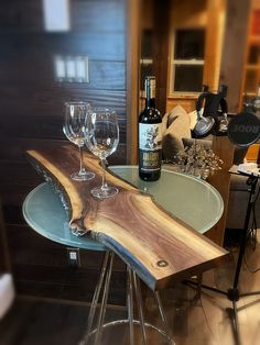 two wine glasses sitting on top of a wooden table next to a bottle of wine